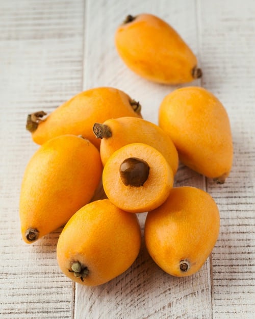 šťavnaté plody mišpule na dřevěném pozadí