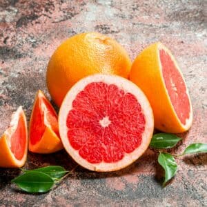 grapefruit - rozkrájený na půlky a čtvrtky s lístkami okolo