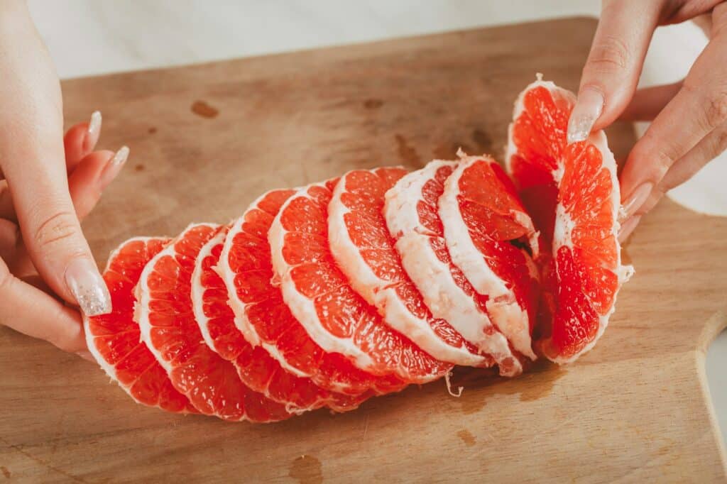 grapefruit - položený na dřevěném prkénku připravený na konzumaci.